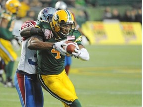 Adarius Bowman, right, of the Edmonton Eskimos, hauls in a pass in front of Jerald Brown of the Montreal Alouettes at Commonwealth Stadium in Edmonton on Friday, Sept. 12, 2014.