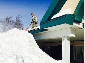 An airman with the New York Air National Guard shovels snow off the roof of an assisted living facility in West Seneca, N.Y. The Buffalo area has been bombarded with more than two metres of snow.