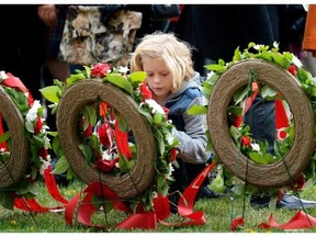 Alyssa Smith, 8, granddaughter of RCMP Cpl. Jim Galloway, lays a flower in his memory at the 16th Annual Police and Peace Officers Memorial Day ceremony at the Alberta Legislature grounds on Sept. 28, 2014.