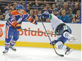 Andrew Ference (21)of the Edmonton Oilers, take out Zack Kassian of the Vancouver Canucks at Rexall Place in Edmonton.