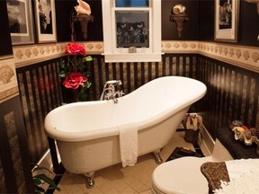 The bathroom’s slipper tub offers simple pampering amidst dramatic wall decor.