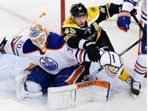 Boston Bruins center David Krejci (46), of the Czech Republic, tangles with Edmonton Oilers goalie Ben Scrivens (30) during the first period of an NHL hockey game, Thursday, Nov. 6, 2014. (AP Photo/Charles Krupa)