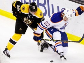 Boston Bruins right-winger Reilly Smith, left, and Edmonton Oilers defenceman Keith Aulie vie for the puck during NHL action Nov. 6, 2014 in Boston. The Bruins beat the Oilers 5-2.