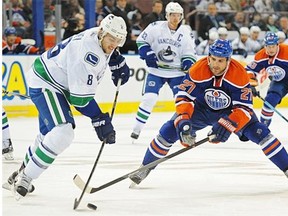 Boyd Gordon (27)of the Edmonton Oilers, chases down Christopher Tanev (8) of the Vancouver Canucks on Oct. 17, 2014, at Rexall Place in Edmonton.