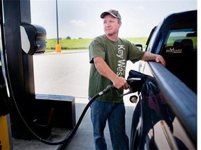 In this July 1, 2014 file photo, a man pumps gas into his truck.