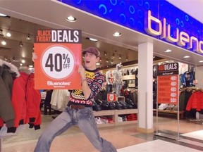 Etienne Van Der Korput, an employee of Bluenotes at Southgate Centre promotes Black Friday specials with a sign.