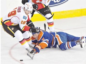 Calgary Flames’ David Jones has the upper hand as he battles for the puck with Edmonton Oilers’ Taylor Hall during NHL action at Rexall Place on Thursday. The Flames were 5-2 winners.