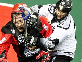 Calgary Roughnecks defenceman Dan MacRae was on the receiving end of a hard hit by Edmonton Rush forward Jarrett Davis during third quarter NLL action at the Scotiabank Saddledome on March 14, 2014.
