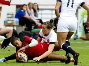 Canada winger Magali Harvey gets tackled by England centre Emily Scarratt during the women’s rugby World Cup final at Jean Bouin Stadium in Paris on Aug. 17, 2014.