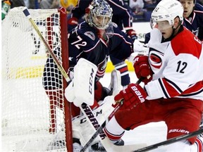 Carolina Hurricanes captain Eric Staal, right, tries to settle the puck in front of Columbus Blue Jackets goalie Sergi Bobrovsky during NHL action in Columbus on March 18, 2014.