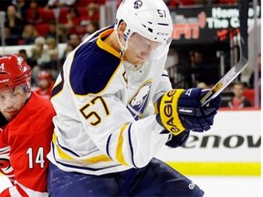Carolina Hurricanes’ Nathan Gerbe (14) and Buffalo Sabres’ Tyler Myers (57) skate for the puck during the second period of an NHL hockey game in Raleigh, N.C., on Oct. 14, 2014.