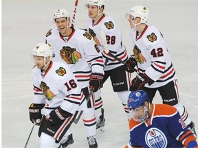 Chicago Blackhawks players celebrate a goal as Edmonton Oilers forward Nail Yakupov skates away during NHL action at Rexall Place in Edmonton, November 22, 2014.