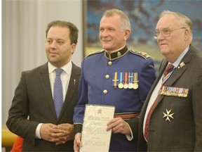 Chief Rod Knecht, middle, of the Edmonton Police Service, receives his commission from Alberta Minister of Justice Jonathan Denis, left, and Alberta Lt.-Gov. Donald S. Ethell.