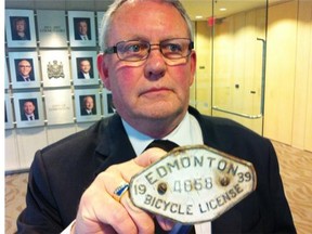 Coun. Ed Gibbons would like to require cycling commuters to buy a licence to remind them they’re vehicles. He holds a 1939 Edmonton bike licence from his family antique collection.