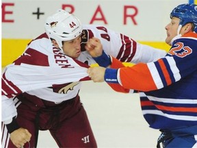 Coyotes’ B.J. Crombeen, left, and Oilers’ Matt Hendricks fight during Edmonton’s NHL pre-season game against Arizona at Rexall Place on Wednesday, Oct. 1, 2014.