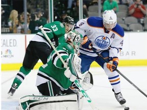 Dallas Stars’ Kari Lehtonen (32) of Finland defends the net as Edmonton Oilers left wing Taylor Hall (4) attempts a shot in the second period of an NHL Hockey game, Tuesday, Jan. 14, 2014, in Dallas. The Stars’ Alex Goligoski (33) watches on the play.