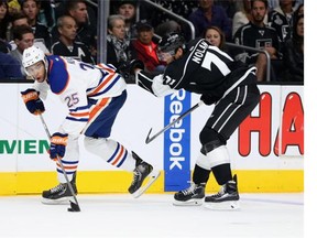 Darnell Nurse #25 of the Edmonton Oilers is pursued by Jordan Nolan #71 of the Los Angeles Kings for the puck in the second period at Staples Center on October 14, 2014 in Los Angeles, California.