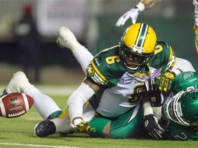 Edmonton Eskimos defensive back Alonzo Lawrence forces Saskatchewan Roughriders running back Anthony Allen to fumble during the second half of a Canadian Football League game at Mosaic Stadium in Regina on Nov. 8, 2014.