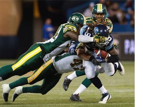 Edmonton Eskimos defensive lineman Cameron Sheffield makes illegal contact with Toronto Argonauts running back Curtis Steele’s helmet while making a tackle with teammate J.C. Sherritt (47) during the Canadian Football League game at Rogers Centre in Toronto on Oct. 4, 2014.