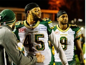 Edmonton Eskimos Dexter McCoil, centre, hugs an injured teammate in the dying second of fourth quarter CFL Western Final football action against the Calgary Stampeders in Calgary, Sunday, Nov. 23, 2014.