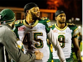 Edmonton Eskimos linebacker Dexter McCoil, centre, hugs an injured teammate in the dying seconds of Sunday’s Canadian Football League West Division final against the Calgary Stampeders at McMahon Stadium.