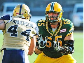 Edmonton Eskimos offensive lineman Simeon Rottier gets set to block a Winnipeg Blue Bombers player during a Canadian Football League game at Commonwealth Stadium on Sept. 14, 2013.