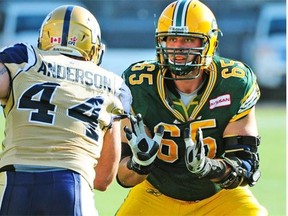 Edmonton Eskimos offensive lineman Simeon Rottier protects quarterback Mike Reilly during a Canadian Football League game against the Winnipeg Blue Bombers at Commonwealth Stadium on Sept. 14, 2013.