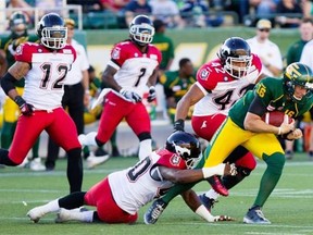 Edmonton Eskimos quarterback Matt Nichols is nearly brought down by Calgary Stampeders defensive lineman Shawn Lemon #40 during Saturday’s Canadian Football League game at Commonwealth Stadium.