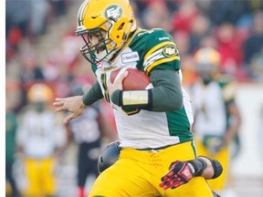 Edmonton Eskimos’ quarterback Mike Reilly, left, can’t escape the clutches of Calgary Stampeders’ Juwan Simpson during first half CFL Western Final action in Calgary on Nov. 23, 2014.
