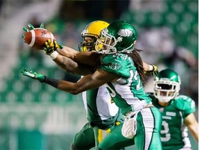 Edmonton Eskimos receiver Fred Stamps gets his hands on a pass during a Canadian Football League game at Regina’s Mosaic Stadium before the ball is knocked away by Saskatchewan Roughriders defensive back Woodny Turenne on Nov. 8, 2014.