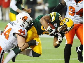 Edmonton Eskimos running back John White gets tackled by B.C. Lions linebacker Adam Bighill during Saturday’s Canadian Football League game against the B.C. Lions at Commonwealth Stadium.