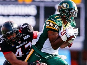 Edmonton Eskimos’ Shamawd Chambers, right, tries to get away from Calgary Stampeders’ Maalik Bomar during second-half CFL football action in Calgary on Sept. 1, 2014. The Stampeders improved to 8-1 with a 28-13 victory.