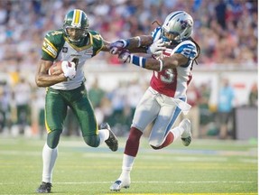 Edmonton Eskimos slotback Adarius Bowman stiff-arms Montreal Alouettes defensive back Chris Smith to score a touchdown during a Canadian Football League game at Molson Stadium in Montreal on Aug. 8, 2014.