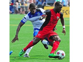 FC Edmonton’s Kareem Moses, left, tries to get the ball away from San Antonio Scorpions’ Trevin Caesar during a North American Soccer League game at Clarke Field on Aug. 3, 2014.