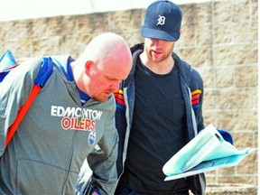 Edmonton Oilers assistant equipment manager Brad Harrison carries defenceman Nick Schultz’s hockey gear on April 28, 2013, after the 2013-14 NHL regular season.