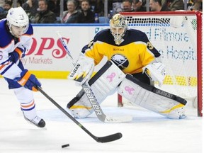 Edmonton Oilers centre Mark Arcobello tries to deflect the puck past Buffalo Sabres goaltender Michal Neuvirth during Friday’s National Hockey League game at First Niagara Center in Buffalo, N.Y.
