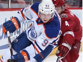 Edmonton Oilers centre Ryan Nugent-Hopkins skates with the puck past Phoenix Coyotes defenceman Zbynek Michalek during their game Friday, April 4, 2014, in Glendale, Ariz., won by the Oilers 3-2 in a shootout.