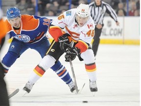 Edmonton Oilers defenceman Justin Schultz tries to stop David Wolf of the Calgary Flames during NHL pre-season action at Rexall Place on Sept. 21, 2014.