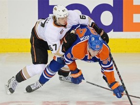 Edmonton Oilers defenceman Oscar Klefbom (right) is checked by Anaheim Ducks centre Rickard Rakell (left) during first period National Hockey League game action in Edmonton on April 6, 2014.