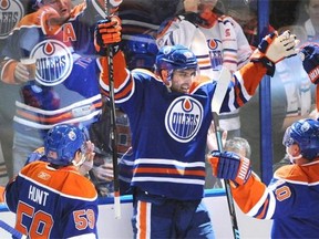 Edmonton Oilers forward Teddy Purcell, centre, celebrates scoring the Oilers’ first goal with Nail Yakupov and Brad Hunt against the Calgary Flames in the Oilers season-opening NHL game at Rexall Place in Edmonton, Oct. 9, 2014.
