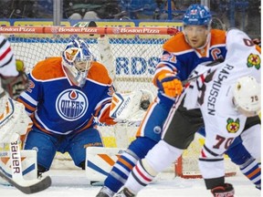Edmonton Oilers goalie Richard Bachman makes a glove save as defenceman Andrew Ference battles for position with Chicago Blackhawks centre Dennis Rasmussen during Sunday’s NHL pre-season game at Saskatoon.
