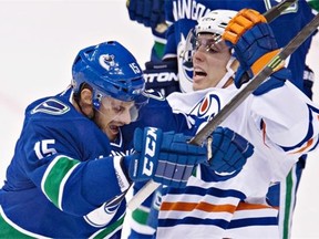 Edmonton Oilers left wing David Perron (57) crashes into Vancouver Canucks centre Brad Richardson (15) during the first period of NHL action in Vancouver, B.C., Saturday, Oct. 11, 2014.