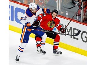 Edmonton Oilers left wing Jesse Joensuu, left, and Blackhawks centre Andrew Shaw battle for the puck during the second period of their NHL game on Sunday, Nov. 10, 2013, in Chicago.