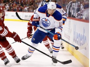 Edmonton Oilers’ Nail Yakupov flips the puck away from Arizona Coyotes’ Michael Stone during the first period of an NHL hockey game at Gila River Arena in Glendale, Ariz., on Wednesday, Oct. 15, 2014.