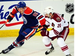 Edmonton Oilers rookie Leon Draisaitl tries to cut around Chris Summers of the Arizona Coyotes during a National Hockey League pre-season game at Rexall Place on Oct. 1, 2014.