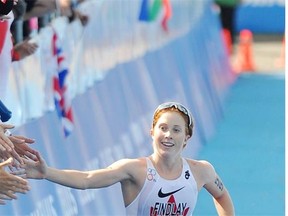 Edmonton’s Paula Findlay high fives fans before crossing the finish line in the Elite Women’s 2014 ITU World Triathlon Final in Edmonton on Saturday Aug. 30, 2014.