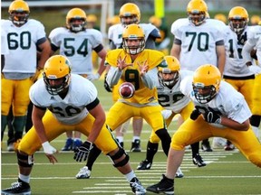 Fifth-year quarterback Ryan Schwartz (No. 9) takes the snap during University of Alberta Golden Bears football training camp drills Aug. 22, 2014, at Edmonton’s Foote Field.