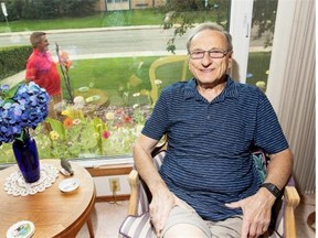 Zan Figol sits in his living room across from the neighbourhood school as his neighbour Peter Koziol walks up to his door.