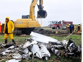 Firefighters, along with RCMP and Transportation Safety Board investigators, recover the wreckage of a small plane that crashed near Stettler in June 2011. Two brothers were killed in the crash.
