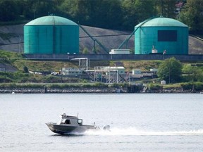 A fishing boat in North Vancouver passes the Kinder Morgan Burnaby Terminal in Burnaby, B.C., on Friday May 2, 2014.